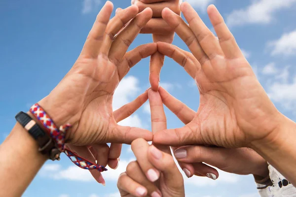 Handen van hippie vrienden maken vredesteken over hemel — Stockfoto