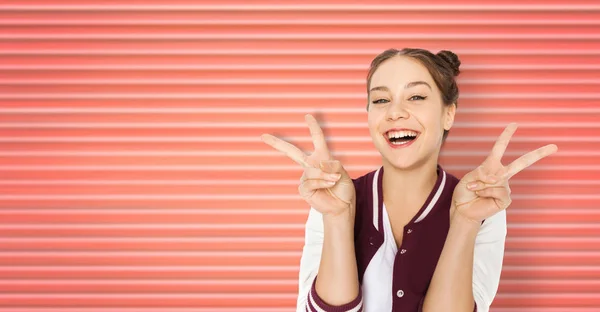 Glücklich lächelndes Teenager-Mädchen zeigt Friedenszeichen — Stockfoto