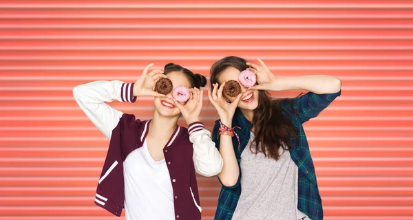 Happy teenage girls or friends with donuts on eyes — Stock Photo, Image