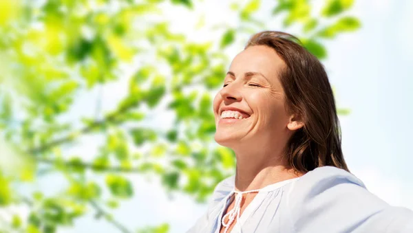 Mujer feliz sobre fondo verde natural —  Fotos de Stock