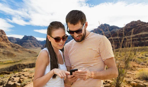 Couple with smartphone in summer over grand canyon — Stock Photo, Image