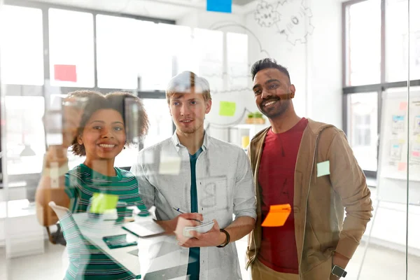 Equipe criativa feliz no escritório placa de vidro — Fotografia de Stock