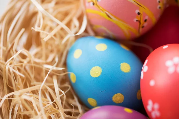 Primer plano de huevos de Pascua de colores en paja —  Fotos de Stock