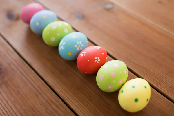 Row of colored easter eggs on wooden table — Stock Photo, Image