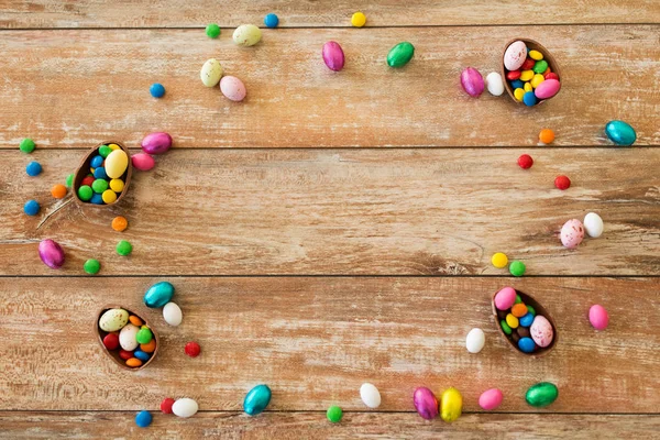 Huevos de chocolate y gotas de caramelo en mesa de madera —  Fotos de Stock