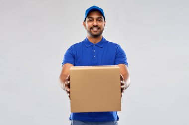 happy indian delivery man with parcel box in blue clipart