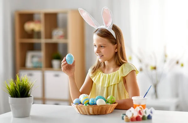 Felice ragazza con uova di Pasqua colorate a casa — Foto Stock