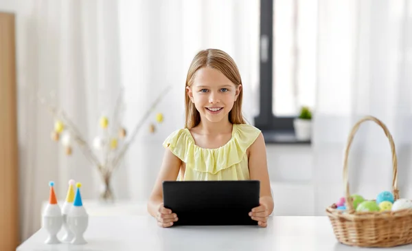 Happy girl with tablet pc and easter eggs at home — Stock Photo, Image