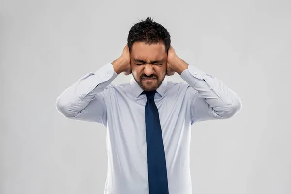 Indian businessman covering ears with hands — Stock Photo, Image