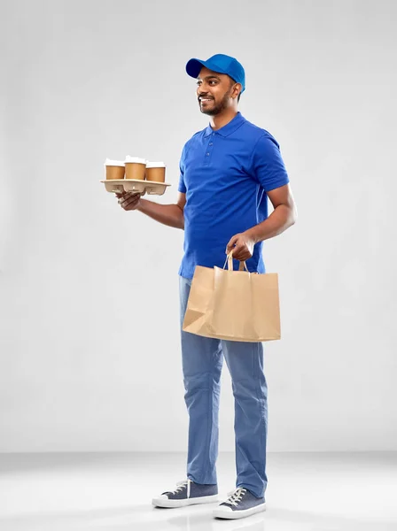 Happy indian delivery man with food and drinks — Stock Photo, Image