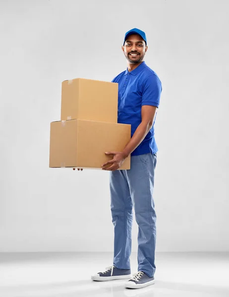 Happy indian delivery man with parcel boxes — Stock Photo, Image