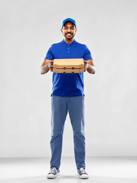 Homem de entrega indiano feliz com caixas de pizza em azul — Fotografia de Stock