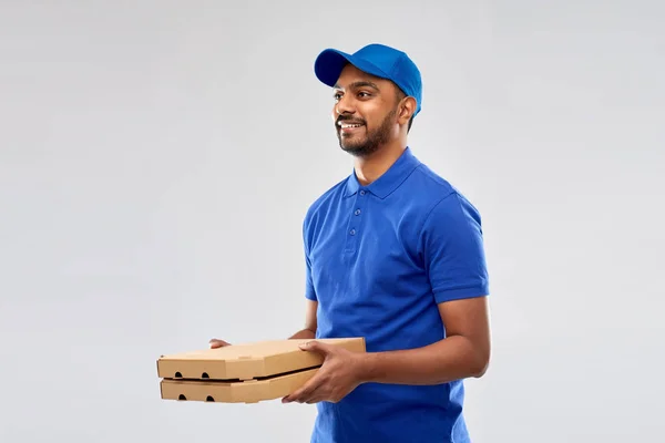 Щасливий індійський чоловік доставки з коробками піци в синьому — стокове фото