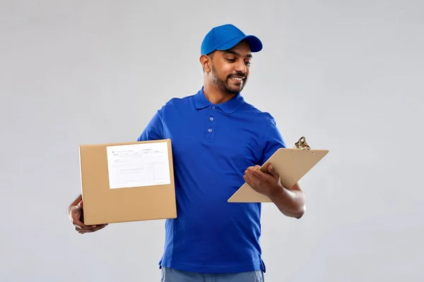 Repartidor indio con caja de paquetes y portapapeles —  Fotos de Stock