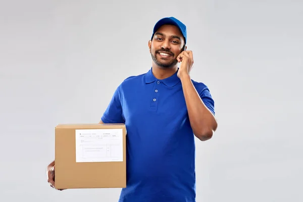 Homem de entrega indiano com smartphone e caixa de encomendas — Fotografia de Stock