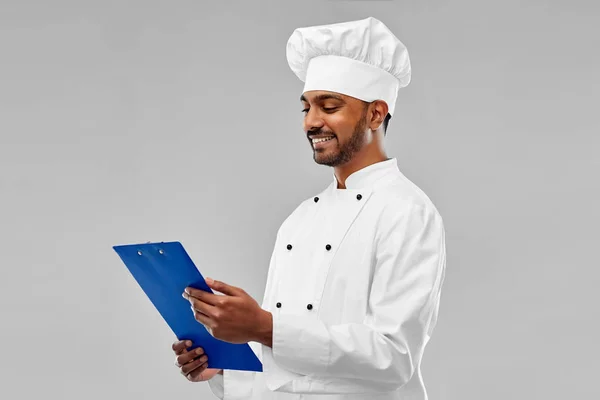 Feliz macho indio chef en toque con portapapeles —  Fotos de Stock