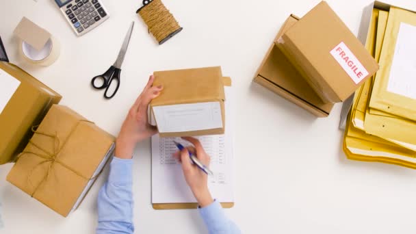 Woman with parcels and clipboard at post office — Stock Video