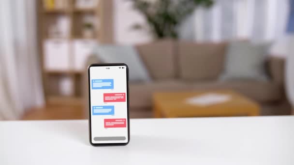 Smartphone met SMS-berichten op het scherm op tafel — Stockvideo