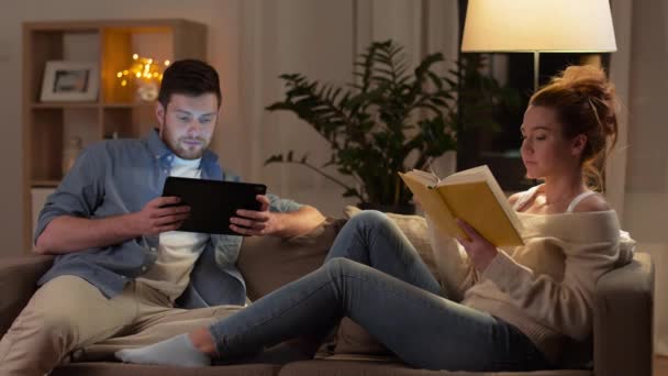 Casal com computador tablet e livro em casa — Vídeo de Stock