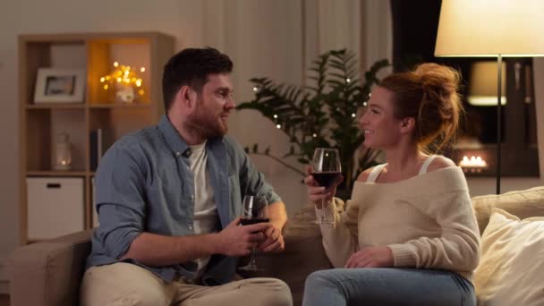 Casal feliz beber vinho tinto em casa à noite — Vídeo de Stock