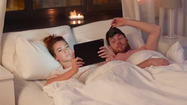 Woman using tablet pc and disturbed man awaking — Stock Video