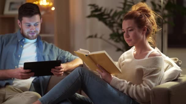 夫妇与平板电脑和书在家里 — 图库视频影像