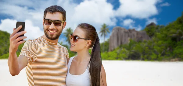 Casal feliz tomando selfie por smartphone na praia — Fotografia de Stock