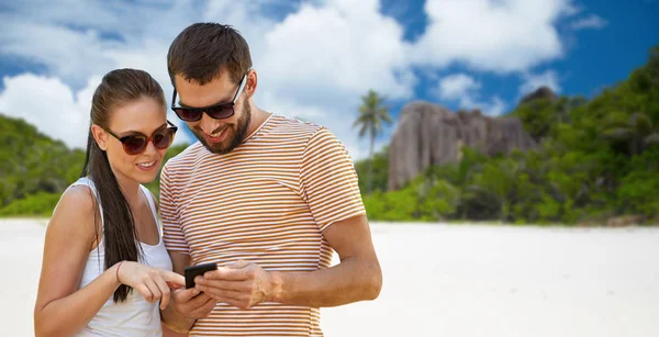 Casal feliz com smartphone na ilha das seicheles — Fotografia de Stock