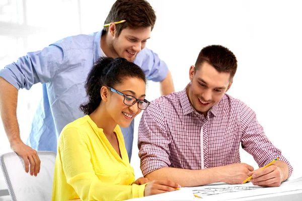 Creative team with blueprint working at office — Stock Photo, Image