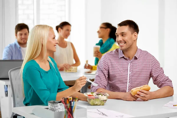 Happy colleagues having lunch and eating at office — Stock Photo, Image