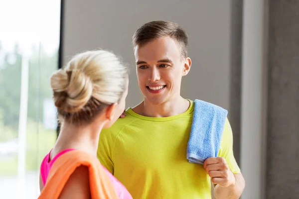 Couple heureux avec des serviettes dans la salle de gym — Photo