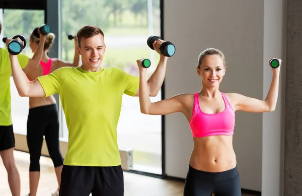 Pareja con mancuernas haciendo ejercicio en el gimnasio — Foto de Stock