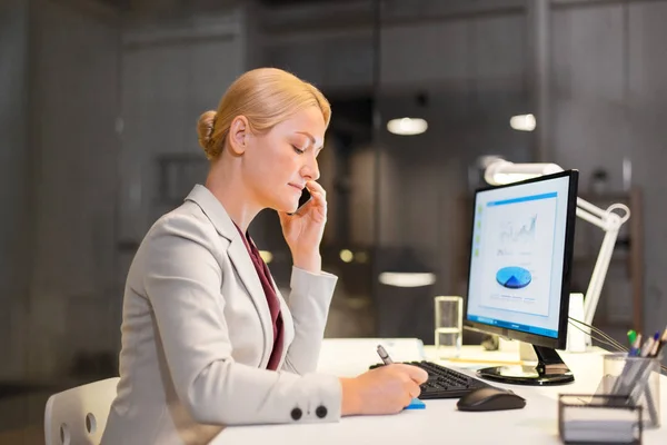 Mujer de negocios llamando a sartphone en la oficina nocturna — Foto de Stock