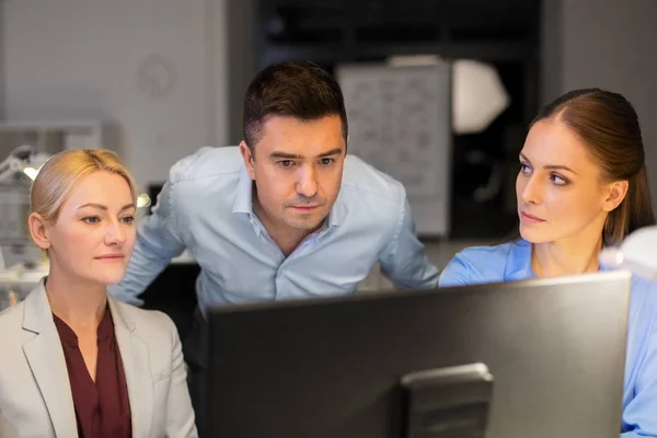 Бизнес-команда с компьютером, работающим поздно в офисе — стоковое фото