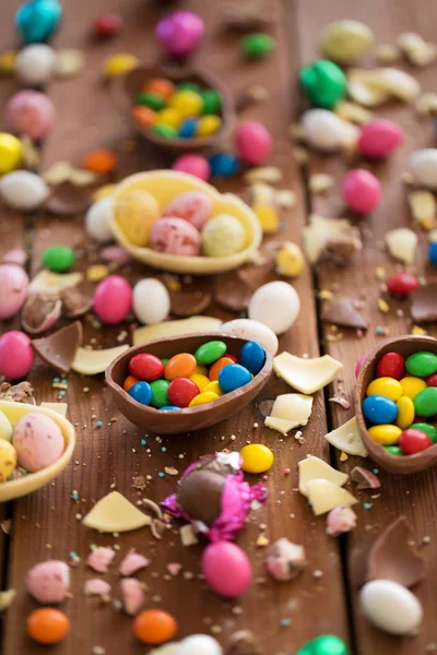 Choklad ägg och godis droppar på träbord — Stockfoto