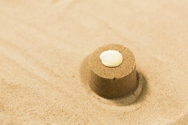 Kum şekil kalıp ile yaz sahilde deniz hayvanı kabuğu tarafından yapılan — Stok fotoğraf