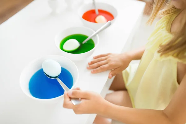Menina colorir ovos de Páscoa por tintura líquida em casa — Fotografia de Stock