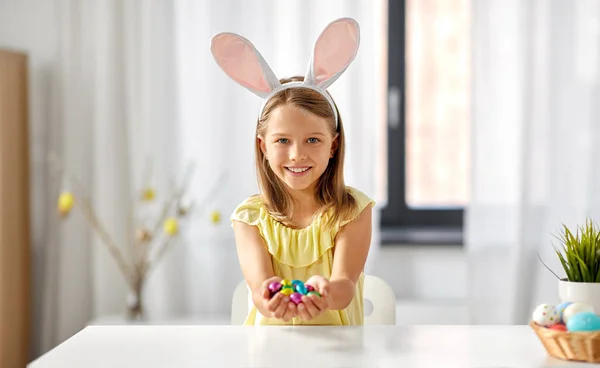 Menina feliz com ovos de Páscoa de chocolate em casa — Fotografia de Stock