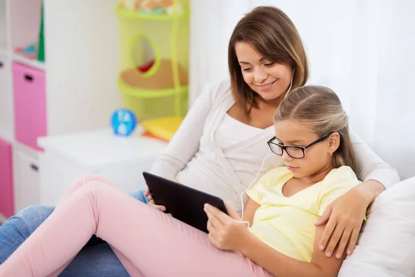 Feliz madre e hija con la tableta PC en casa —  Fotos de Stock