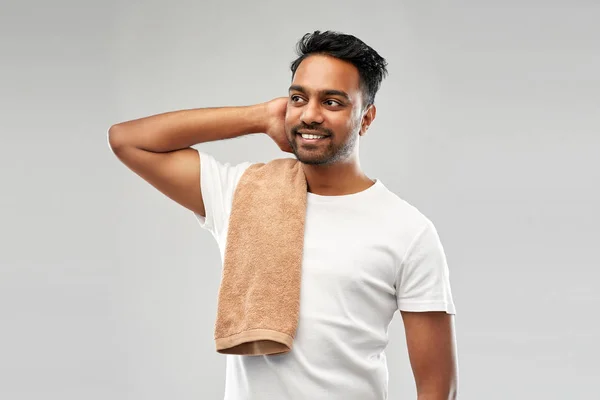 Hombre indio sonriente con toalla sobre fondo gris —  Fotos de Stock