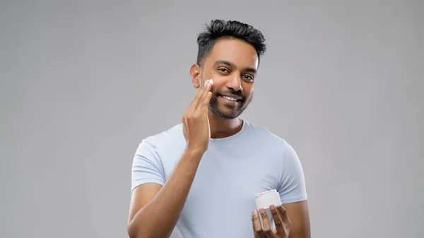Glücklicher indischer Mann cremt sein Gesicht ein — Stockfoto