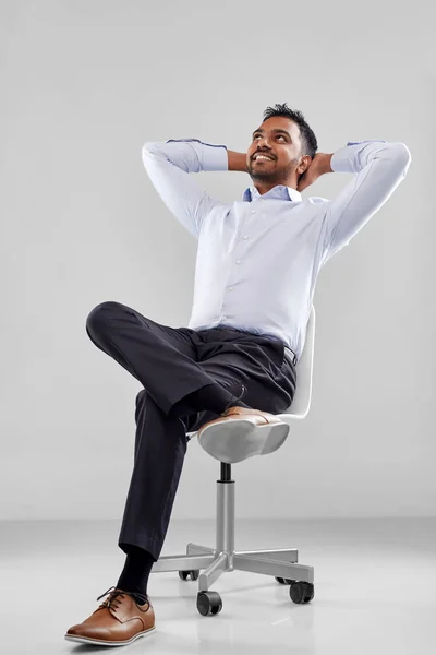 オフィスの椅子に座って笑顔のインドのビジネスマン — ストック写真