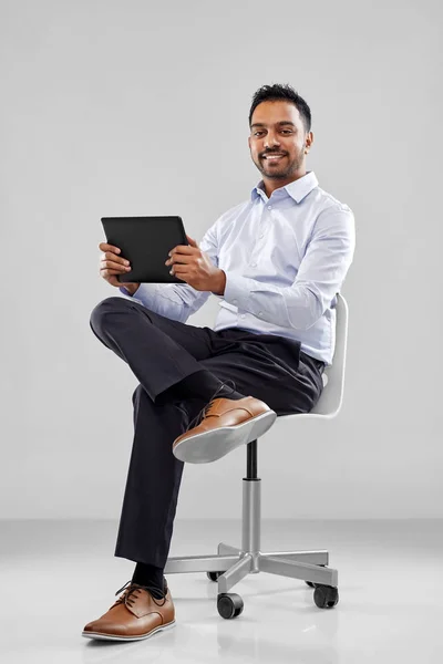 Indyjski biznesmen z komputera typu tablet na krzesło biurowe — Zdjęcie stockowe