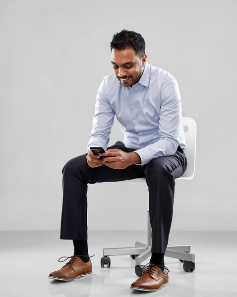 Uśmiechający się indyjski biznesmen, siedząc na fotelu biurowym — Zdjęcie stockowe