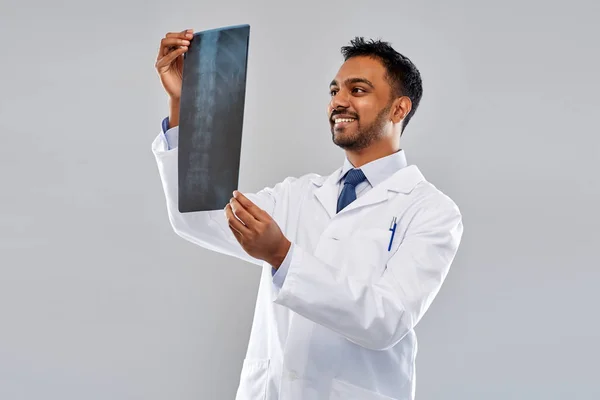 Smiling indian doctor looking at spine x-ray — Stock Photo, Image