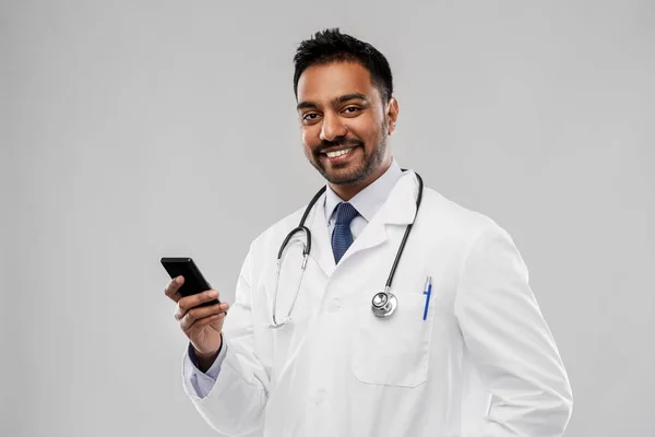 Sorridente índio masculino médico com smartphone — Fotografia de Stock