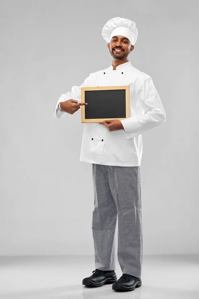 Happy male indian chef in toque with chalkboard — Stock Photo, Image