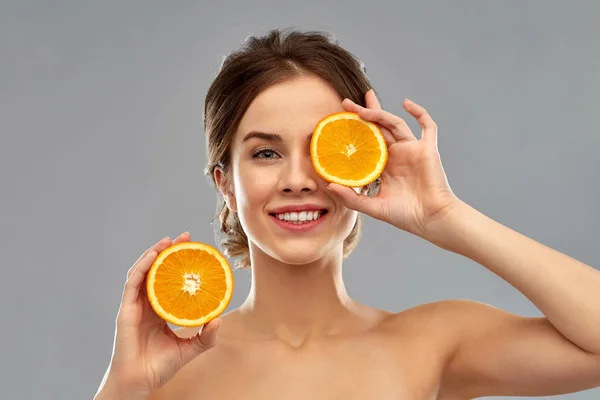 Χαμογελαστό γυναίκα με πορτοκάλια σε γκρι φόντο — Φωτογραφία Αρχείου