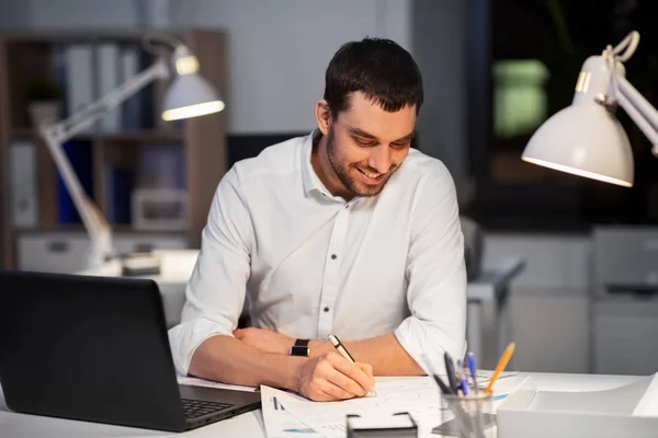 Uomo d'affari con documenti che lavorano all'ufficio notturno — Foto Stock