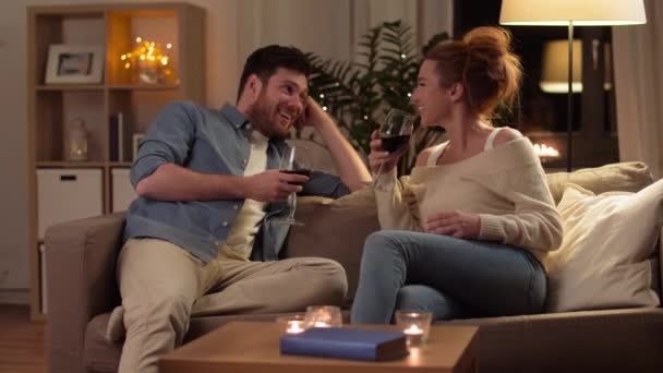 Casal feliz beber vinho tinto em casa à noite — Vídeo de Stock